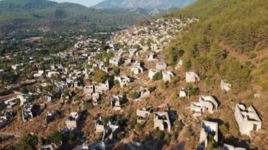 Türkiye 'de Fethiye İdeniz yakınlarındaki Kayaky hayalet kasabasının havadan görüntüsü. Terk edilmiş eski bir Yunan köyü. Taş evlerle dolu mahalleleri olan bir klasik. Kamera eğimle paralel gidiyor..