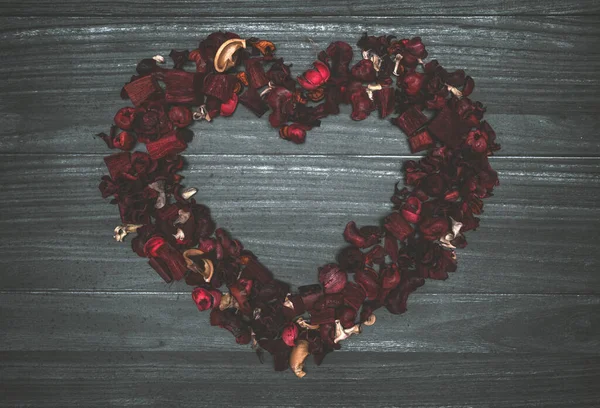 stock image Background with gray wooden planks, leaves and red dry flowers forming a heart                    