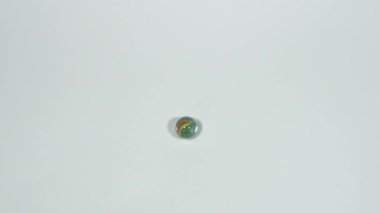 Mermer kaza, parlak mırıldanan oyuncak cam küreler, beyaz arka plan.