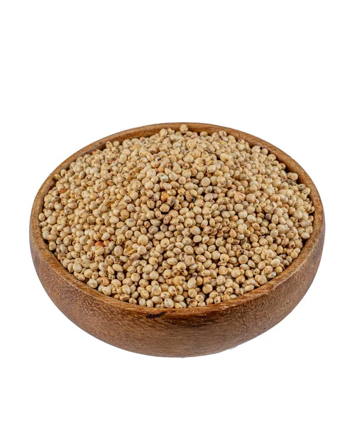 Beyaz arka planda yuvarlak kasede Sorghum tanelerinin üst görüntüsü diyet için sağlıklı gıda süpürgesi.