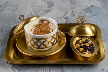 Cup of salep milky traditional hot drink of Turkey with cinnamon served  in a vintage cup served with nuts