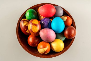 Beyaz arka planda bir kasede çok renkli Paskalya yumurtaları. Pastel renkli Paskalya yumurtaları.