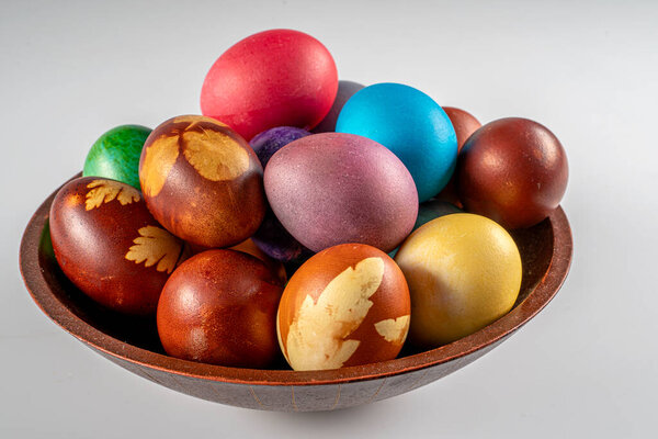 Multicolored Easter eggs in a bowl at white background. Pastel colored Easter eggs.