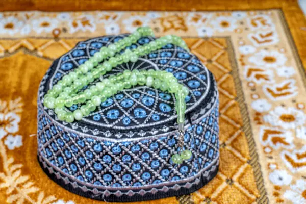 İşlemeli erkek kafatası şapkası, duada görülen tespih boncukları. Ramazan kavramı..