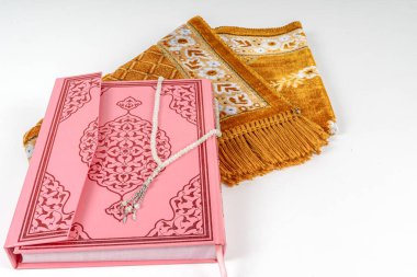 Kuran ve tespih boncukları paspasın üzerinde görülüyor. Ramazan Kavramı.