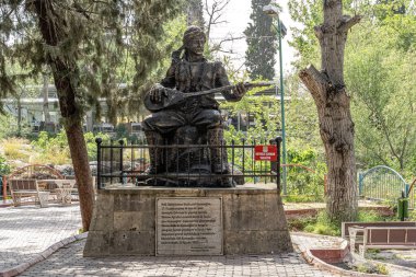 Tarsus, Mersin Türkiye, 19 Nisan 2024: Ünlü halk şairi Karacaoglan 'ın Alayan Şelaleleri bahçesindeki heykeli.
