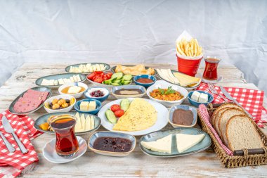 Kahvaltı masası. Geleneksel Türk kahvaltısı çeşitli aperatifler, aperatifler, tatlılar, hamur işleri, et, sıcak ve soğuk yemekler ve çay. Türkçesi 'Serpme Kahvalti'