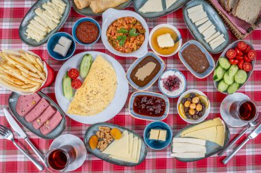 Kahvaltı masası. Geleneksel Türk kahvaltısı çeşitli aperatifler, aperatifler, tatlılar, hamur işleri, et, sıcak ve soğuk yemekler ve çay. Türkçesi 'Serpme Kahvalti'