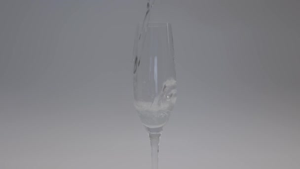 特写镜头下 酒保在白底的杯子里倒入香槟 杯子里有很多气泡 人造照明 慢动作高质量的4K镜头 — 图库视频影像