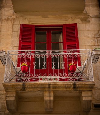 Beautiful, red doors and balcony window frames. European balcony, ancient architecture. High quality photo