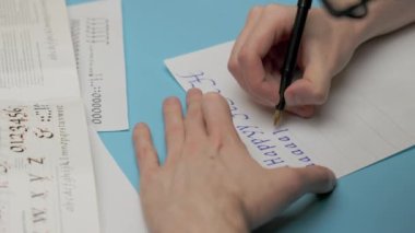 Calligraphy, a man learns to write the letters of the English alphabet correctly. Practice writing and handwriting. High quality 4k footage