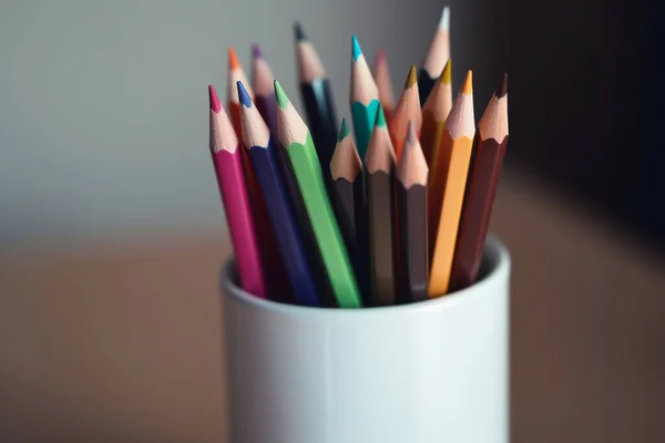 stock image colored wooden pencils for drawing in a white glass on the table. High quality photo