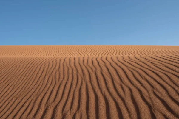 Güneş ışığı altında çölde kum tepeleri ve sahara, Fas ve Afrika 'da mavi bir gökyüzü.