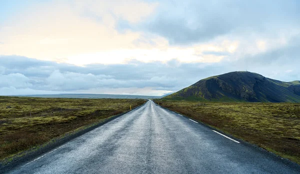 İzlanda 'da dağlarla çevrili bomboş bir yolun ortasında.