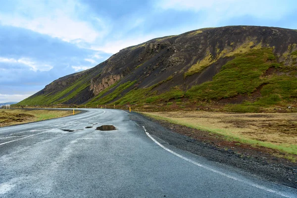İzlanda 'da dağlarla çevrili bomboş bir yolun ortasında.