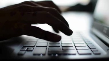 Eller siluette dizüstü bilgisayarda klavyede yazılıyor, tuşların görünümünü kapat