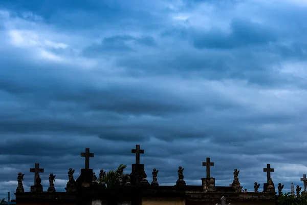 old tombs in the cemetery on a gloomy day with cloudy sky
