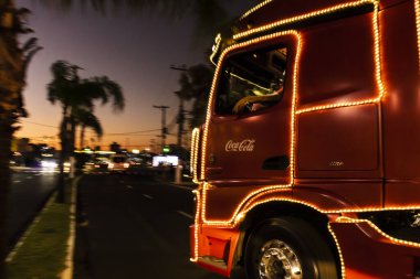 Marilia, Sao Paulo, Brezilya, 15 Kasım 2022: Geleneksel Coca-Cola FEMSA Noel Karavanı, ışıklandırılmış kamyonları, Noel süsleri ve Noel Baba ve Anne 'nin varlığı