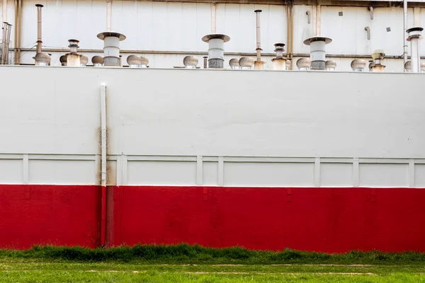Industrial building with metal pipes and red and white walls. Exterior of the food factory in Brazil