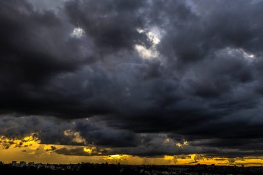 Dark clouds and rainy over the city in Brazil at a sunset