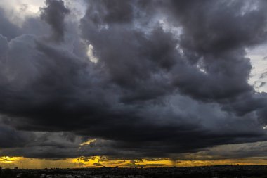 Dark clouds and rainy over the city in Brazil at a sunset