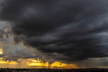 Dark clouds and rainy over the city in Brazil at a sunset