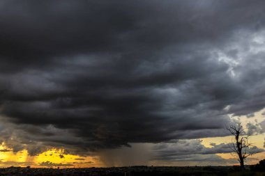 Dark clouds and rainy over the city in Brazil at a sunset