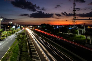 Marilia, Sao Paulo, Brazil, January 26, 2023. traffic on the Highway and silhouette of a telecommunications antenna in Marilia city, during a sunset