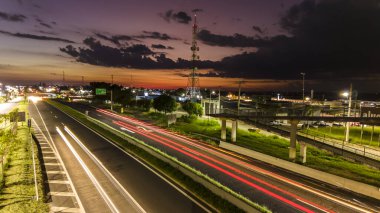 Marilia, Sao Paulo, Brezilya, 26 Ocak 2023, Marilia şehrindeki bir telekomünikasyon anteninin silüeti ve karayolu trafiği gün batımında