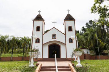 facade of a small white catholic chapel with brown stairs in Brazil