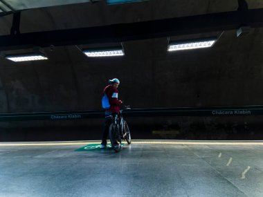 Sao Paulo, Brezilya, 29 Mayıs 2023. Bisikletli bir bisikletçi Sao Paulo şehrindeki metro istasyonunun platformunda duruyor.