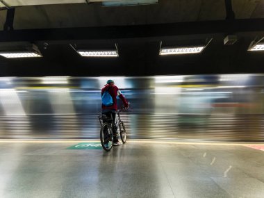 Sao Paulo, Brezilya, 29 Mayıs 2023. Bisikletli bir bisikletçi Sao Paulo şehrindeki metro istasyonunun platformunda duruyor.