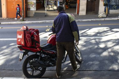Sao Paulo, Brezilya, 20 Temmuz 2023, Sao Paulo şehrindeki müşterilere yiyecek getiren motosikletli işçi ifood..