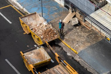 Marilia, Sao Paulo, Brezilya, 31 Ağustos 2023. Marilia şehir merkezindeki bir caddeye yığılmış moloz yığınını kaldıran bir kamyon şoförünün görüntüsü