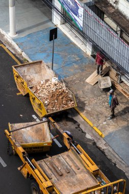 Marilia, Sao Paulo, Brezilya, 31 Ağustos 2023. Marilia şehir merkezindeki bir caddeye yığılmış moloz yığınını kaldıran bir kamyon şoförünün görüntüsü