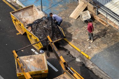 Marilia, Sao Paulo, Brezilya, 31 Ağustos 2023. Marilia şehir merkezindeki bir caddeye yığılmış moloz yığınını kaldıran bir kamyon şoförünün görüntüsü