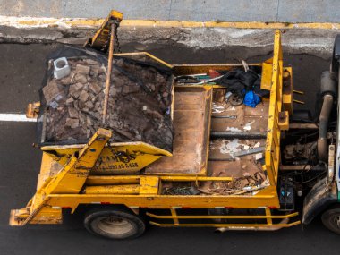 Marilia, Sao Paulo, Brezilya, 31 Ağustos 2023. Marilia şehir merkezindeki bir caddeye yığılmış moloz yığınını kaldıran bir kamyon şoförünün görüntüsü