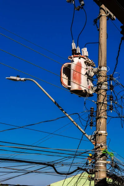 Electric power transformer on a public lighting pole in Brazil