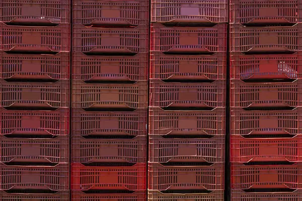 Image of red plastic boxes for carrying fruits and vegetables in a producers market in Brazil