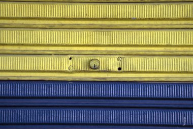 Brezilya 'daki kapalı mağazanın mavi ve sarı desenli demir kapısı