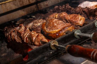 Brezilya usulü biftek pirzolası Brezilya 'da bir churrascaria et lokantasında ızgarada ızgara.