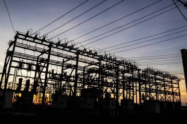 Brezilya 'da elektrik dağıtımı için gün batımında arka planda bulunan alt istasyonun silueti