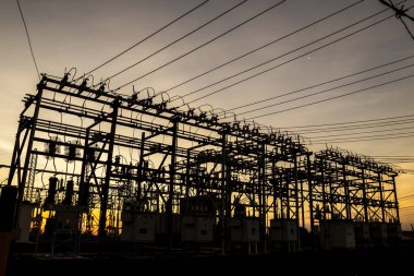 Brezilya 'da elektrik dağıtımı için gün batımında arka planda bulunan alt istasyonun silueti