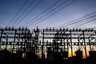 Brezilya 'da elektrik dağıtımı için gün batımında arka planda bulunan alt istasyonun silueti