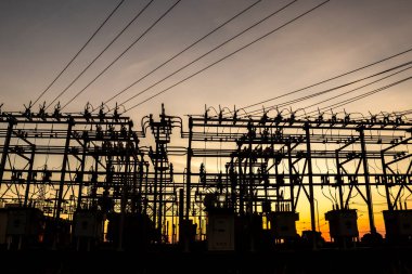 Brezilya 'da elektrik dağıtımı için gün batımında arka planda bulunan alt istasyonun silueti
