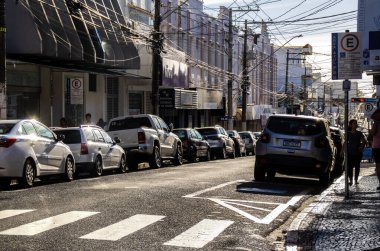 Marilia, Sao Paulo, Brezilya, 13 Aralık 2023. Marilia şehir merkezinde ticari ana caddelerde araçlar ve insanlar hareket ediyor.