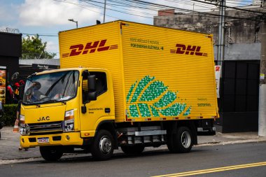 Sao Paulo, Brezilya, 20 Aralık 2023 Sao Paulo şehrinin sokaklarında DHL taşımacılık şirketinin elektrik dağıtım kamyonu. DHL, Alman lojistik şirketi Deutsche Post 'un bir bölümüdür.