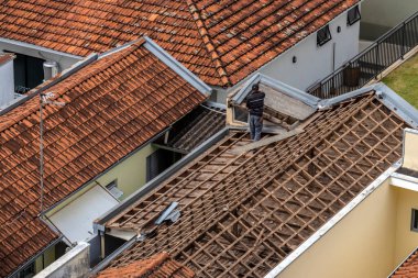 Marilia, Sao Paulo, Brezilya, 29 Ağustos 2023. Mailia şehir merkezindeki ticari bir noktanın çatısını yenilemek için bir evin fayanslarını söken bir işçinin üst görüntüsü