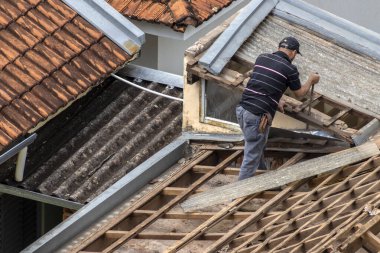 Marilia, Sao Paulo, Brezilya, 29 Ağustos 2023. Mailia şehir merkezindeki ticari bir noktanın çatısını yenilemek için bir evin fayanslarını söken bir işçinin üst görüntüsü