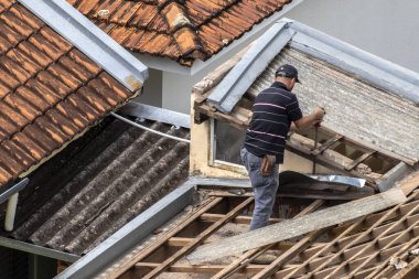 Marilia, Sao Paulo, Brezilya, 29 Ağustos 2023. Mailia şehir merkezindeki ticari bir noktanın çatısını yenilemek için bir evin fayanslarını söken bir işçinin üst görüntüsü